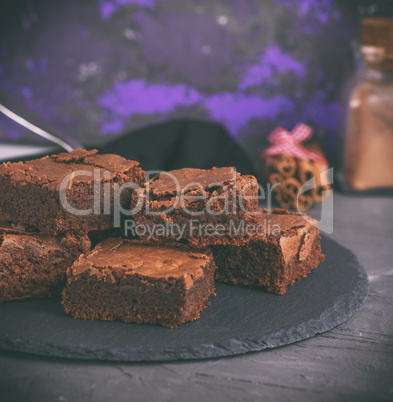 chocolate pieces of brownie on a black graphite plate