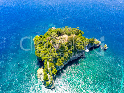 Small Rocky Island in the Ocean and Huts. Aerial View
