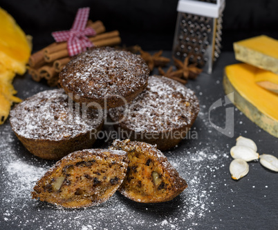 round cupcakes with a pumpkin on a black table