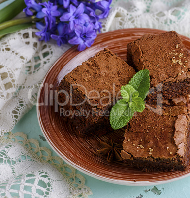 square pieces of chocolate brownie on a brown round plate
