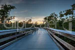 Boardwalk through the swamp, leading to Clam Pass at sunset i