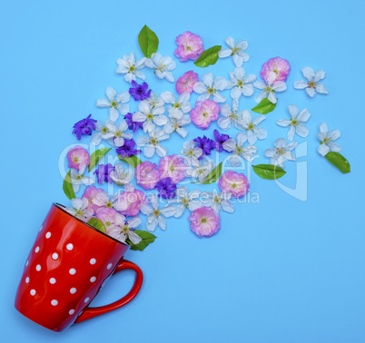of red ceramic mug with white polka dots randomly poured flower