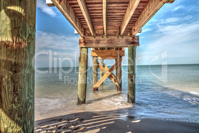 Boardwalk across the White sand beach and aqua blue water of Cla