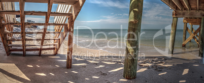 Boardwalk across the White sand beach and aqua blue water of Cla