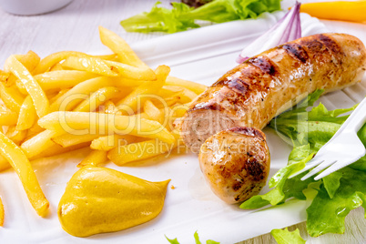 delicious grilled bratwurst with fries and mustard