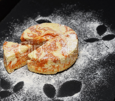 round curd pie with pumpkin on a black background