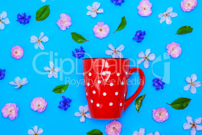 ceramic red mug  with white polka dots on a blue background