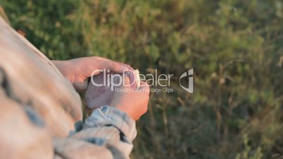 The little girl breaks the sandwich into two parts. Close-up of children's hands and a sandwich. Sunset.