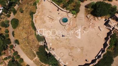 Aerial top view of an old architectural building with tourists on the castle. The national flag is waving on the castle. Spain, Catalonia, Begur Castle