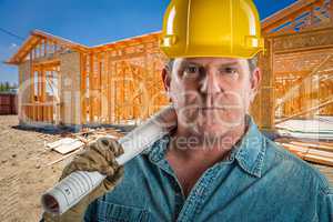 Serious Contractor in Hard Hat Holding Floor Plans At Constructi