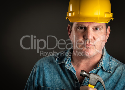 Serious Contractor in Hard Hat Holding Hammer With Dramatic Ligh