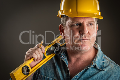 Serious Contractor in Hard Hat Holding Level and Pencil With Dra