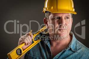 Serious Contractor in Hard Hat Holding Level and Pencil With Dra