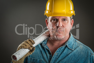 Serious Contractor in Hard Hat Holding Floor Plans With Dramatic