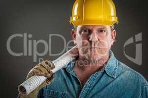 Serious Contractor in Hard Hat Holding Floor Plans With Dramatic