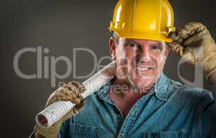 Smiling Contractor in Hard Hat Holding Floor Plans With Dramatic
