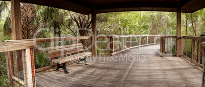 Wooden secluded, tranquil boardwalk along a marsh pond