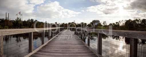 Wooden secluded, tranquil boardwalk along a marsh pond