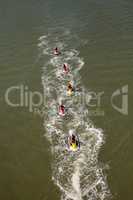 Group of jet skies zip along the ocean in a straight line