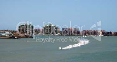 Skyline in the background as a Group of jet skies zip along the