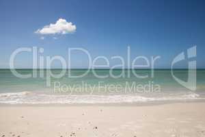 Lone cloud in a Blue sky over white sand of Tigertail Beach