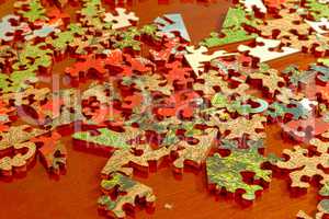 Puzzle pieces spread across a dark wood table
