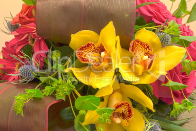 Pink roses, yellow cymbidium , green mums, and palms in a tropic