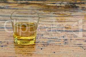 Old, good plum brandy in glass on grunge wooden table
