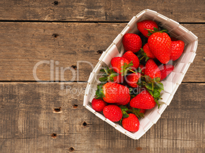 Fresh organic strawberries in a white basket