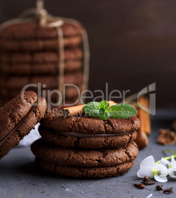 a stack of round chocolate cookies on a black table