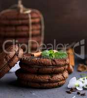 a stack of round chocolate cookies on a black table