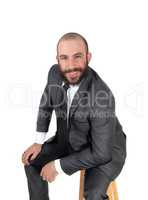 Business man sitting, bending forward, smiling