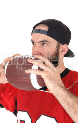 Football player holding his ball on his mouth thinking