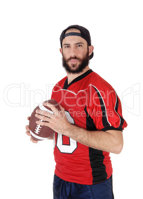 Young football player standing with his football in his hand