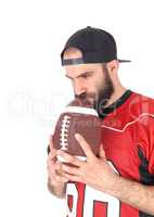 Football player holding his ball on his mouth, thinking