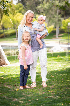 Happy Young Caucasian Mommy and Daughters Portrait In The Park