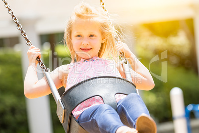 Pretty Young Girl Having Fun On The Swings At The Playground