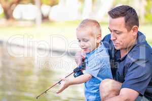 Young Caucasian Father and Son Having Fun Fishing At The Lake
