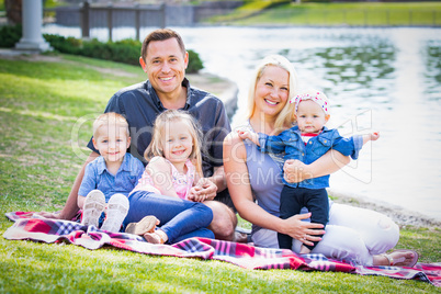 Happy Young Caucasian Family Portrait In The Park