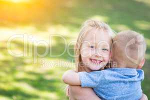 Young Brother and Sister Hugging At The Park