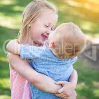 Young Brother and Sister Hugging At The Park