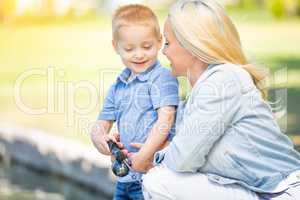 Young Caucasian Mother and Son Having Fun Fishing At The Lake