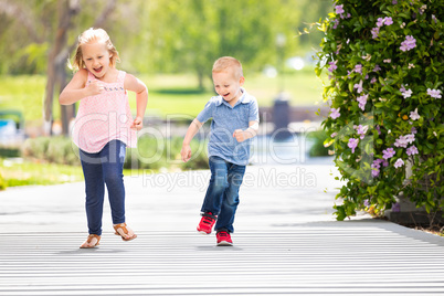 Young Sister and Brother Having Fun Running At The Park