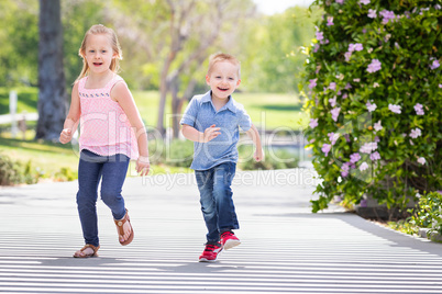 Young Sister and Brother Having Fun Running At The Park