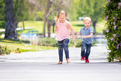 Young Sister and Brother Having Fun Running At The Park