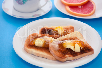 French toast with sliced orange fruit on blue tablecloth