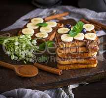 French toast with chocolate and banana slices on a brown wooden