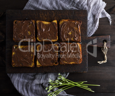 square pieces of fried white bread smeared with chocolate