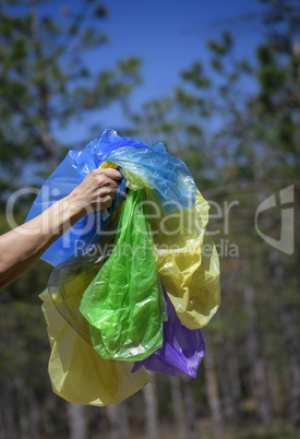 a female hand holds a pile of empty transparent crumpled plastic
