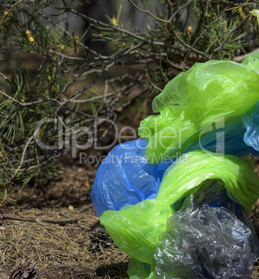 a pile of crumpled transparent empty plastic bags lies under a t